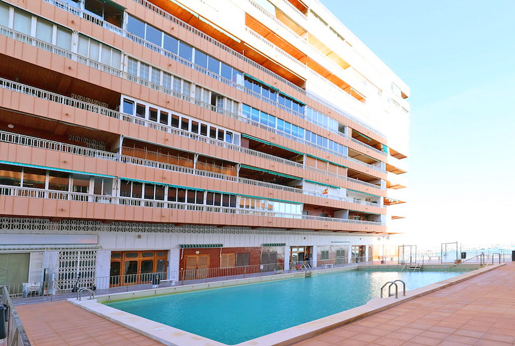zdjęcie prezentuje basen przed apartamentowcem, w którym znajduje się oferowany do sprzedaży luksuowy apartament Hiszpania Torrevieja)