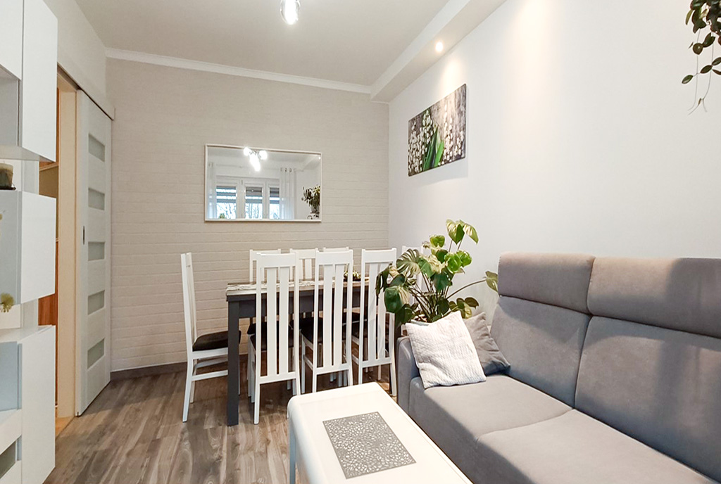 na pierwszym planie salon i jadalnia w luksusowym apartamencie na sprzedaż Legnica okolice