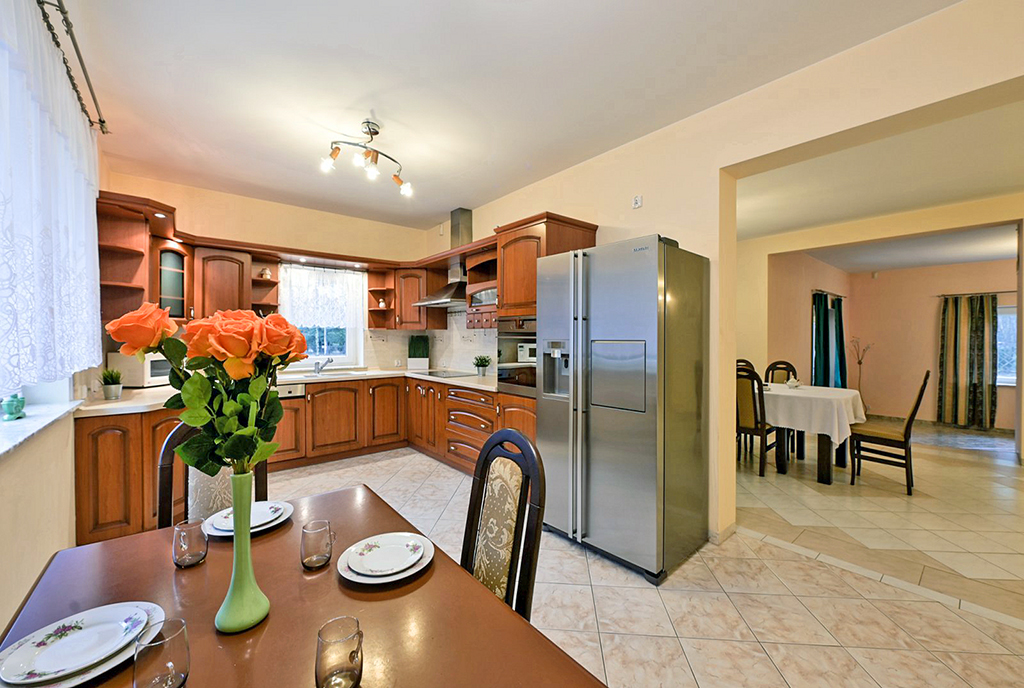 na pierwszym planie jadalnia, w oddali kuchnia w luksusowej willi na sprzedaż Warszawa okolice