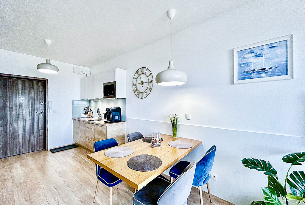 na pierwszym planie jadalnia w luksusowym apartamencie na sprzedaż nad morzem