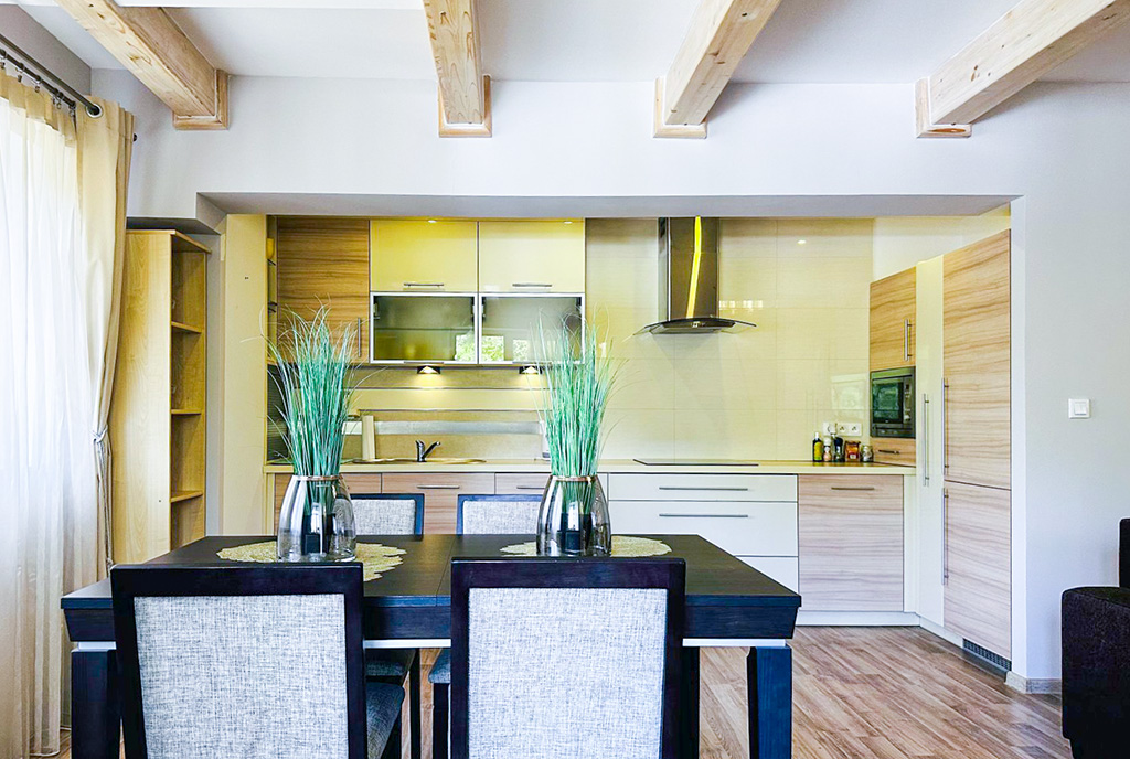 na pierwszym planie jadalnia, w oddali kuchnia w luksusowym apartamencie do wynajmu Słupsk