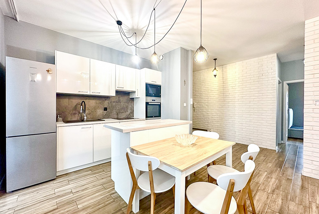 na pierwszym planie jadalnia, w oddali kuchnia w ekskluzywnym apartamencie na sprzedaż Wrocław okolice