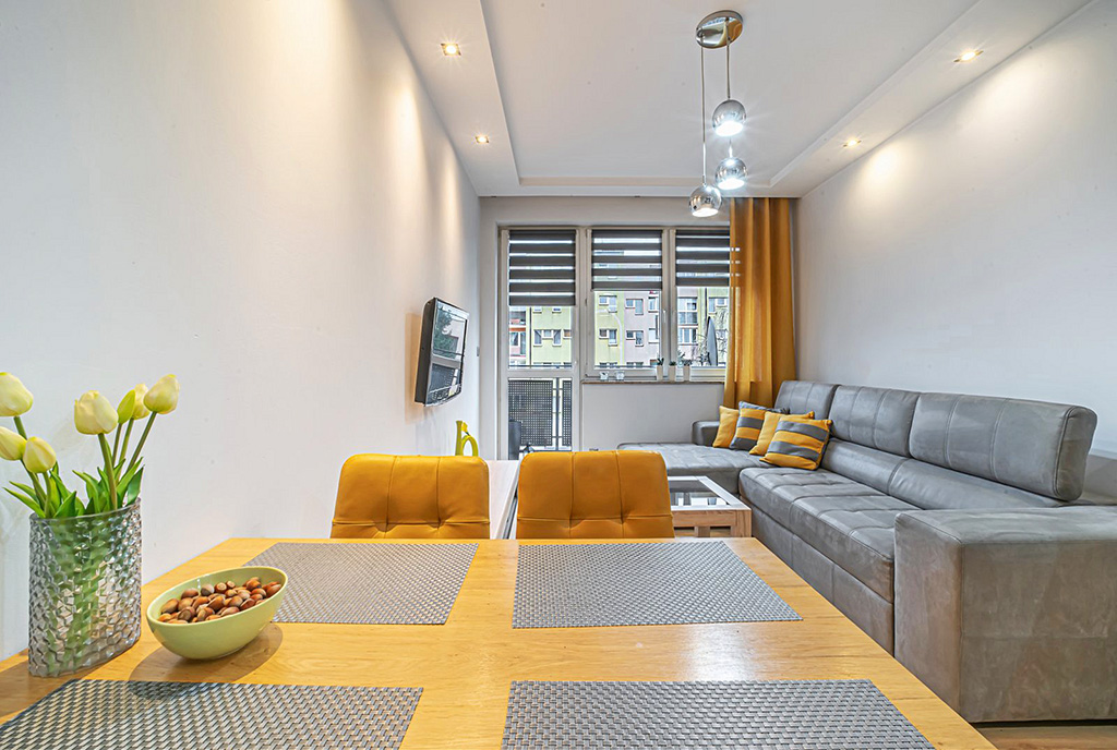 na pierwszym planie jadalnia, w oddali salon w ekskluzywnym apartamencie na wynajem Bolesławiec