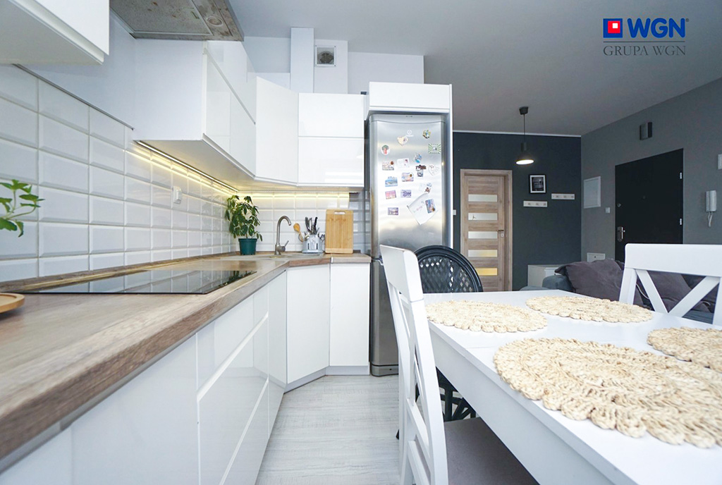 po lewej kuchnia, po prawej jadalnia w luksusowym apartamencie na sprzedaż Konin