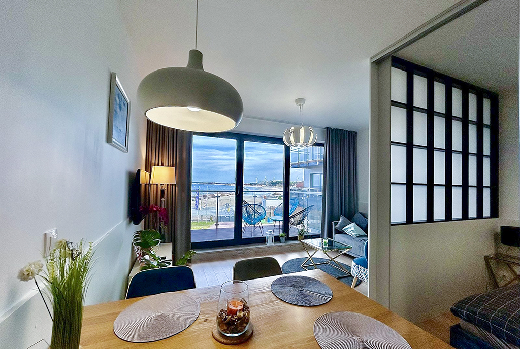 widok na jadalnię i salon w luksusowym apartamencie na sprzedaż nad morzem