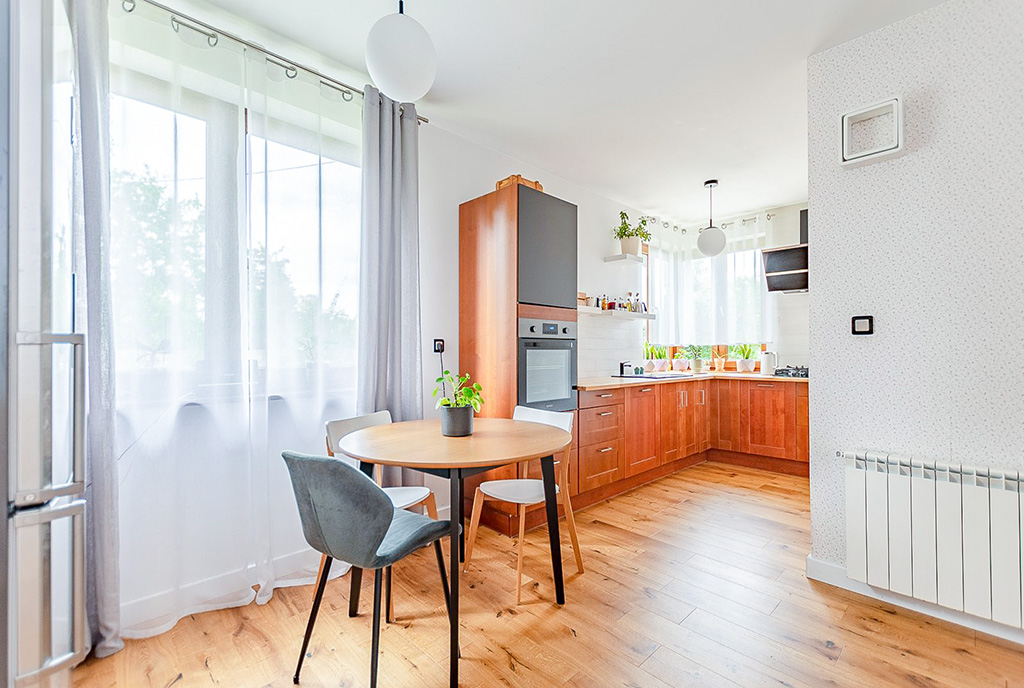 na pierwszym planie jadalnia, w oddali kuchnia w ekskluzywnej willi na sprzedaż Poznań