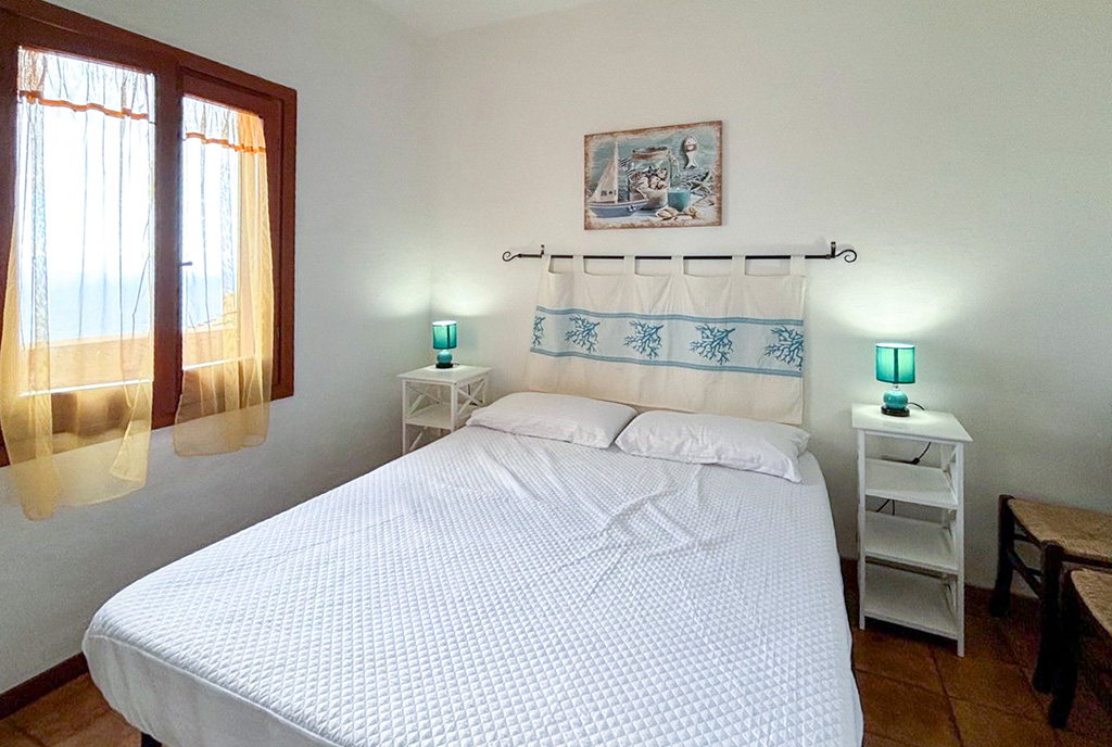 zdjęcie prezentuje kameralną sypialnię w ekskluzywnym apartamencie na sprzedaż Włochy Costa Paradiso