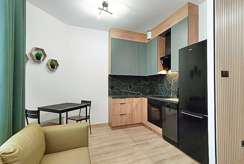 po lewej salon, po prawej kuchnia w ekskluzywnym apartamencie na wynajem Legnica