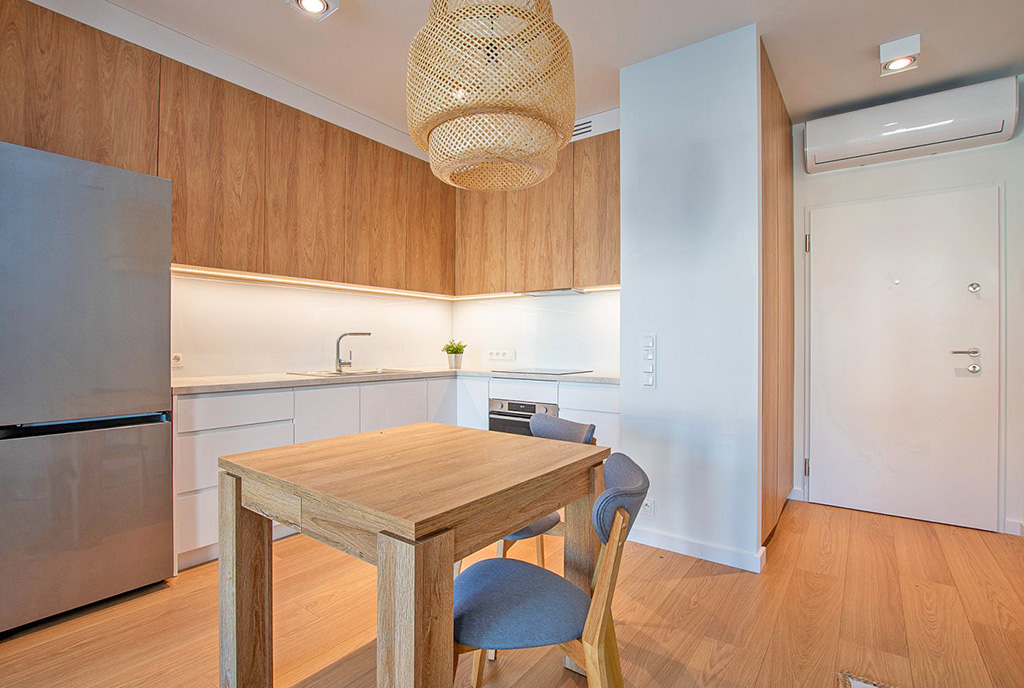 na pierwszym planie jadalnia i kuchnia w luksusowym apartamencie do wynajmu Poznań