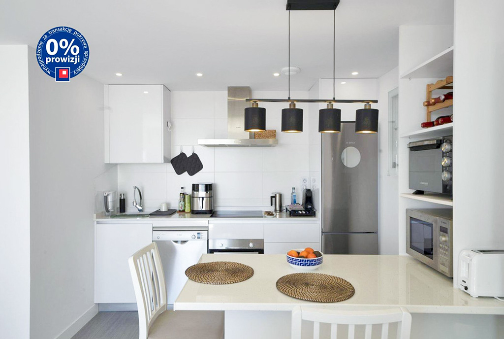 na pierwszym planie jadalnia, w oddali kuchnia w luksusowym apartamencie na sprzedaż Hiszpania (Costa del Sol)