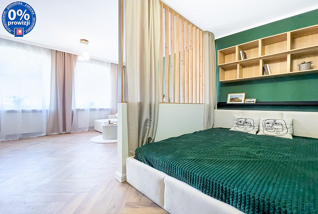 na pierwszym planie sypialnia, w oddali salon w ekskluzywnym apartamencie na sprzedaż Katowice