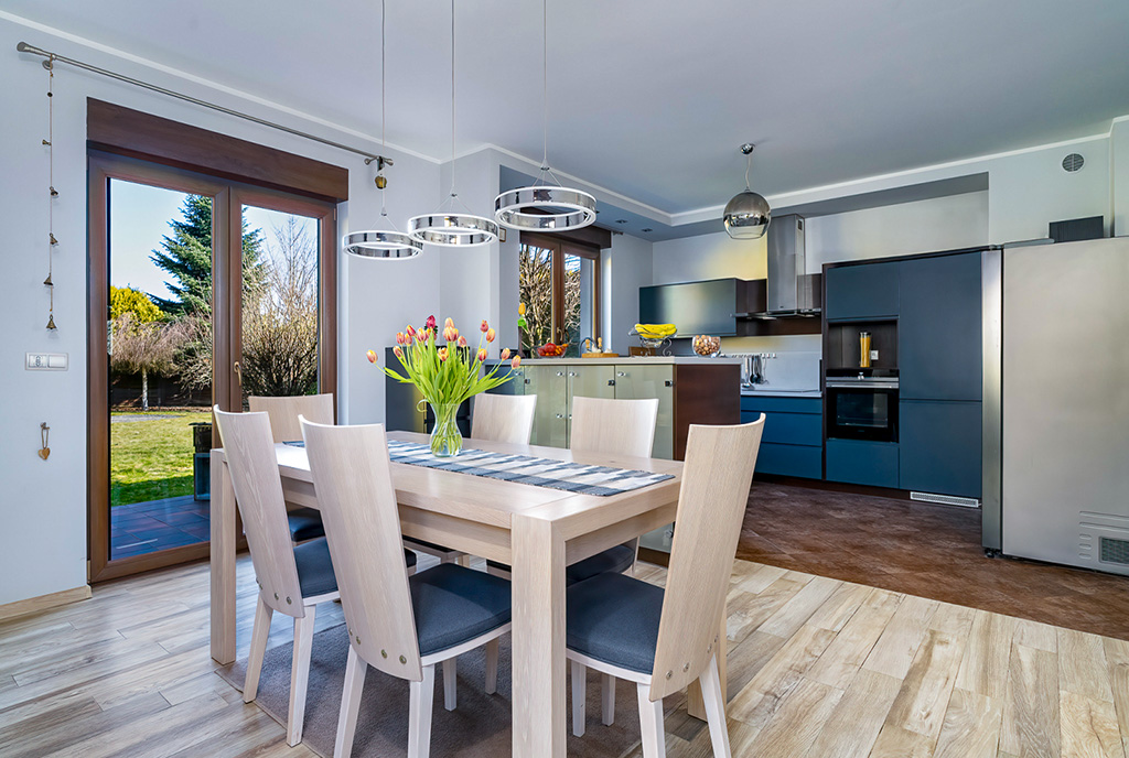 na pierwszym planie jadalnia, w oddali kuchnia w ekskluzywnej willi na sprzedaż Poznań okolice