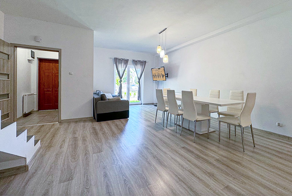 widok z salonu na aneks kuchenny i jadalnię w luksusowym apartamencie na sprzedaż nad morzem