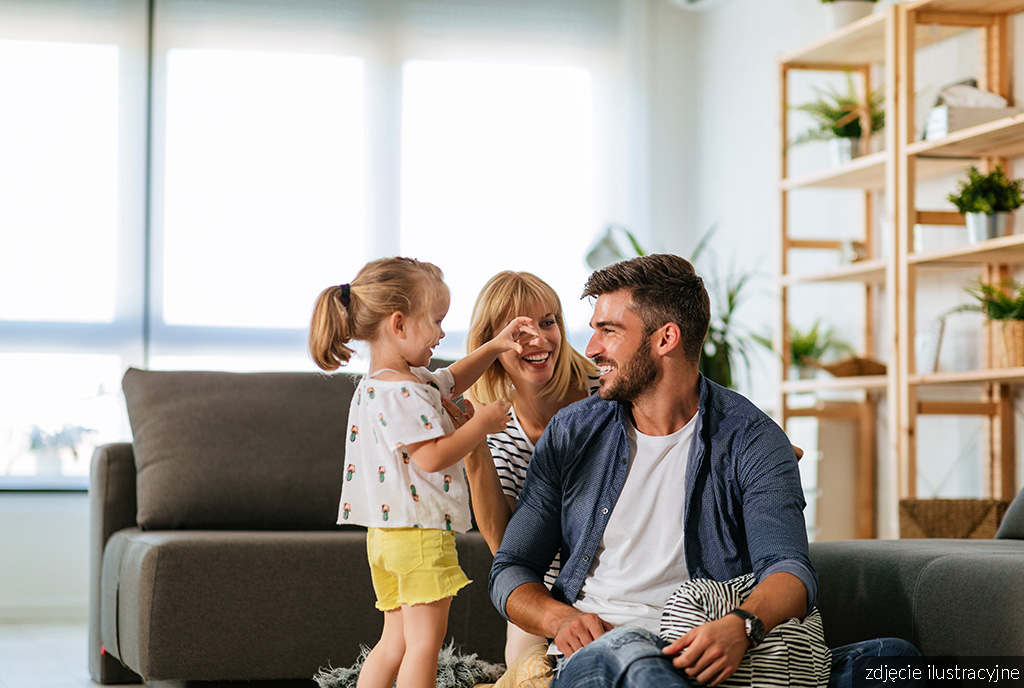 rodzina przesiadująca w pokoju dziennym znajdującym się w ekskluzywnym apartamencie na sprzedaż Gdańsk