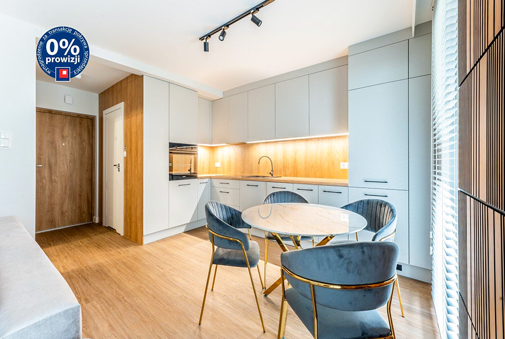 na pierwszym planie jadalnia, w oddali kuchnia w luksusowej willi na sprzedaż nad morzem