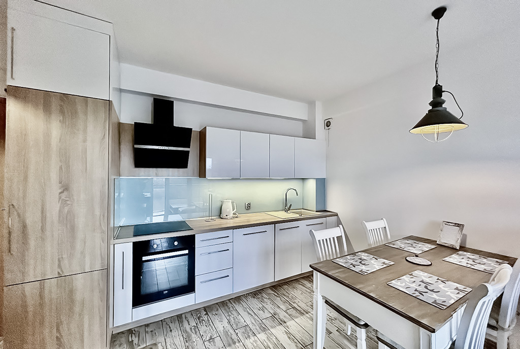 dominująca biel w kuchni luksusowego apartamentu na sprzedaż nad morzem