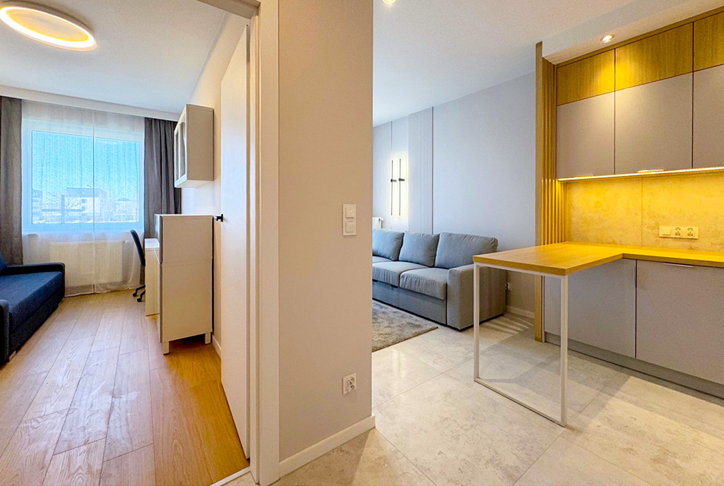po lewej kuchnia, po prawej salon w luksusowym apartamencie do wynajmu Szczecin