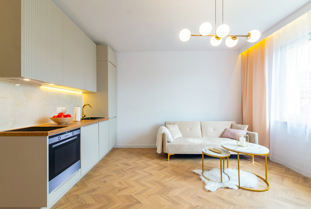 po lewej kuchnia, po prawej pokój gościnny w ekskluzywnym apartamencie na sprzedaż Gdańsk