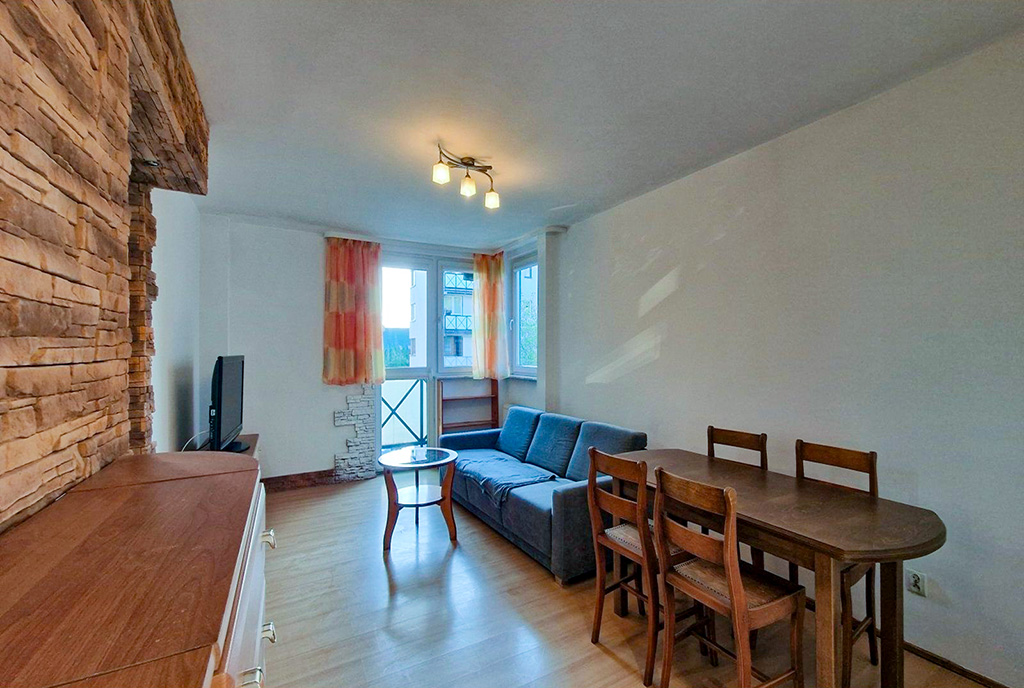 na pierwszym planie jadalnia, w oddali salon w luksusowym apartamencie na sprzedaż Łódź okolice