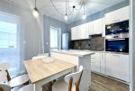 na pierwszym planie jadalnia, w oddali kuchnia w luksusowym apartamencie na sprzedaż Wrocław (okolice)