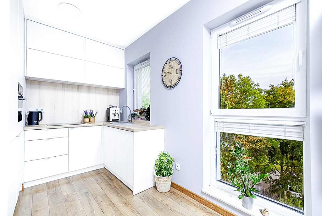 po lewej kuchnia, po prawej okno w luksusowym apartamencie na sprzedaż Poznań