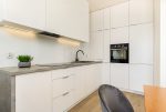 zaprojektowana w bieli kuchnia w luksusowym apartamencie do wynajmu Szczecin