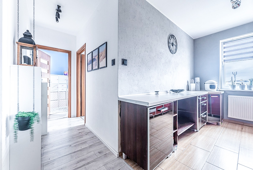 po prawej kuchnia, po lewej przedpokój w ekskluzywnym apartamencie na sprzedaż Gdynia (okolice)