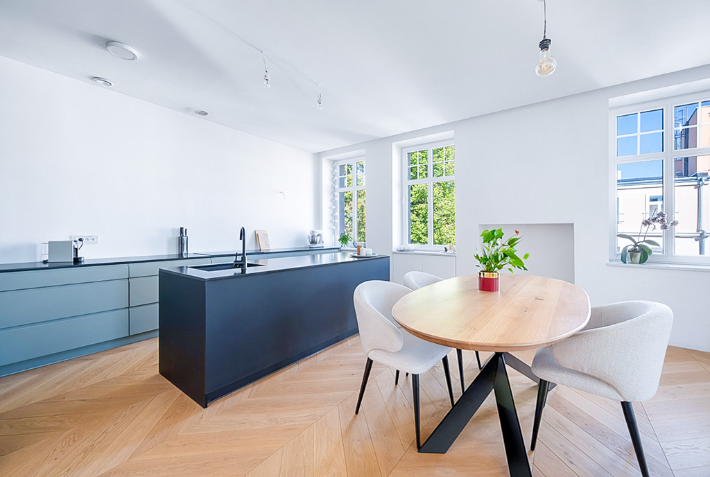 na pierwszym planie jadalnia, w oddali kuchnia w luksusowym apartamencie na sprzedaż Gdańsk