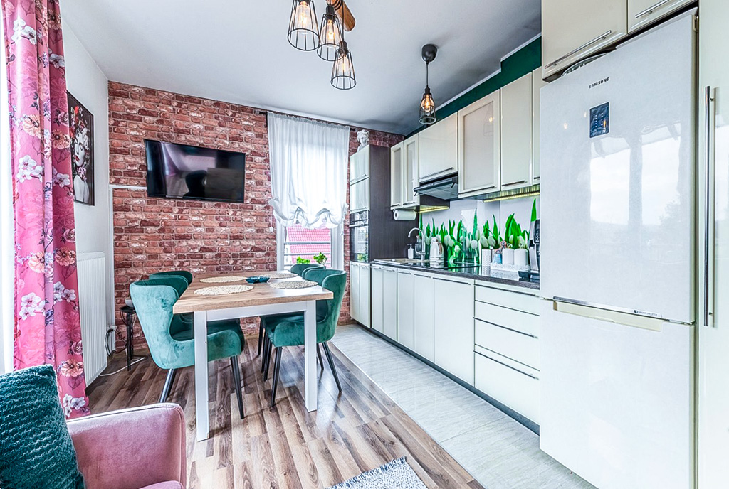 po lewej jadalnia, po prawej kuchnia w luksusowym apartamencie na sprzedaż Gdynia (okolice)