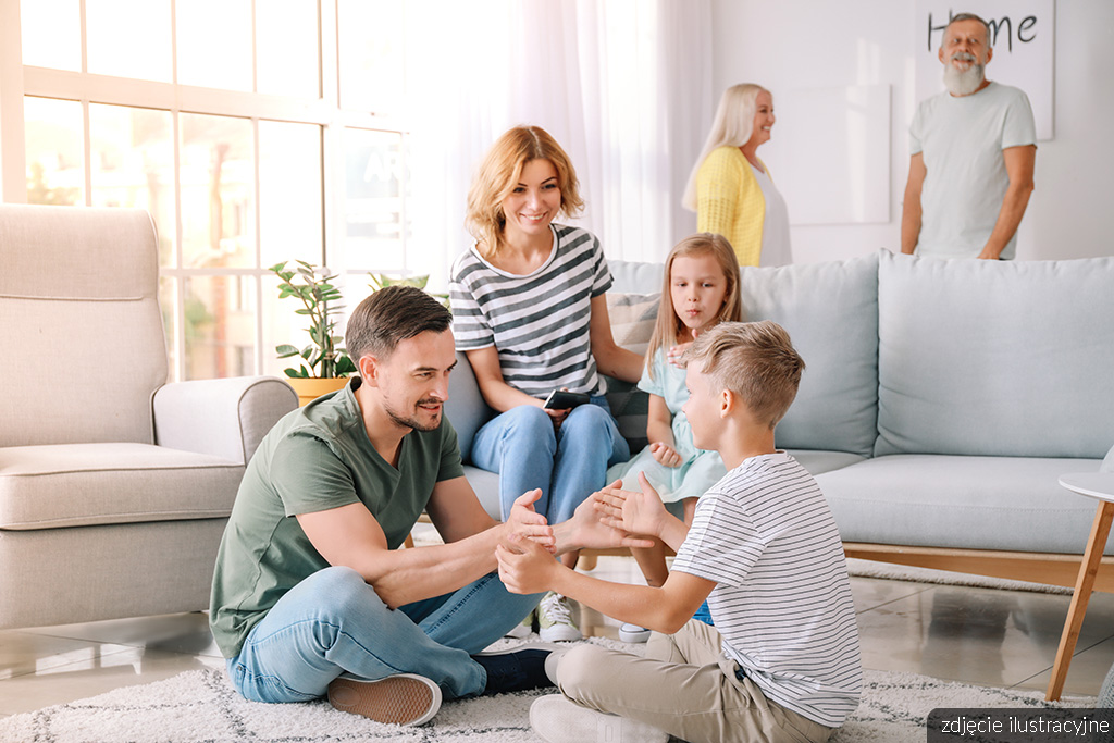 rodzice bawiący się ze swoimi dziećmi w pokoju dziennym ekskluzywnego apartamentu na sprzedaż Gdynia