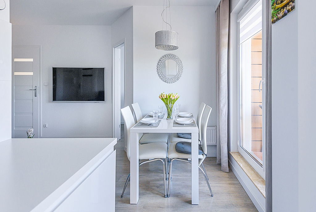 na zdjęciu jadalnia oraz kuchnia w luksusowym apartamencie na sprzedaż nad morzem