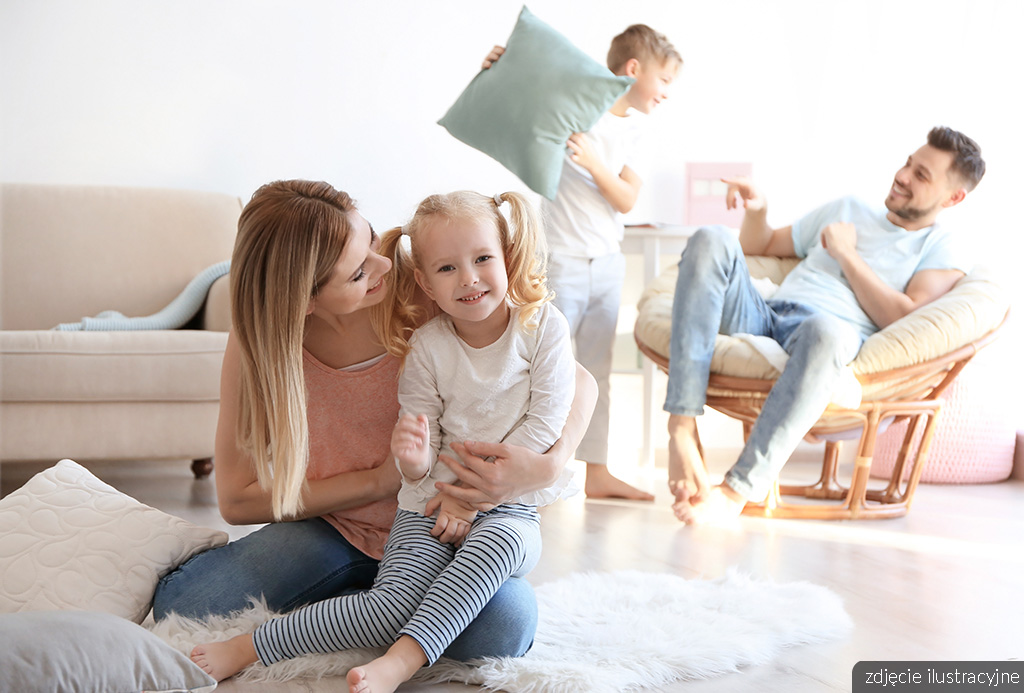 uśmiechnięta rodzina w salonie ekskluzywnego apartamentu na sprzedaż Lublin