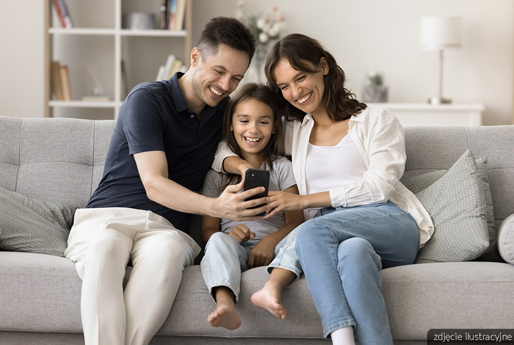 szczęśliwa rodzina w pokoju gościnnym w luksusowym apartamencie na sprzedaż nad morzem