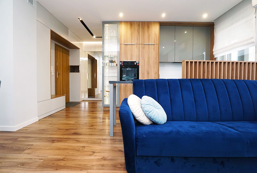 na pierwszym planie salon, w oddali kuchnia w ekskluzywnym apartamencie na sprzedaż Piotrków Trybunalski