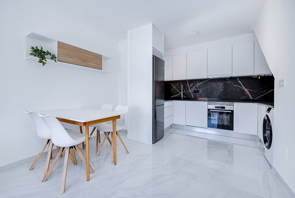 po lewej jadalnia, na wprost kuchnia w luksusowym apartamencie na sprzedaż Hiszpania Torrevieja El Limonar
