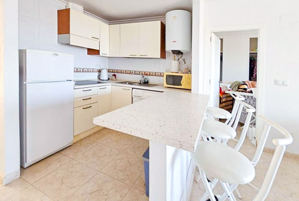 na pierwszym planie jadalnia, w oddali kuchnia w luksusowym apartamencie na sprzedaż Hiszpania Torrevieja La Mata
