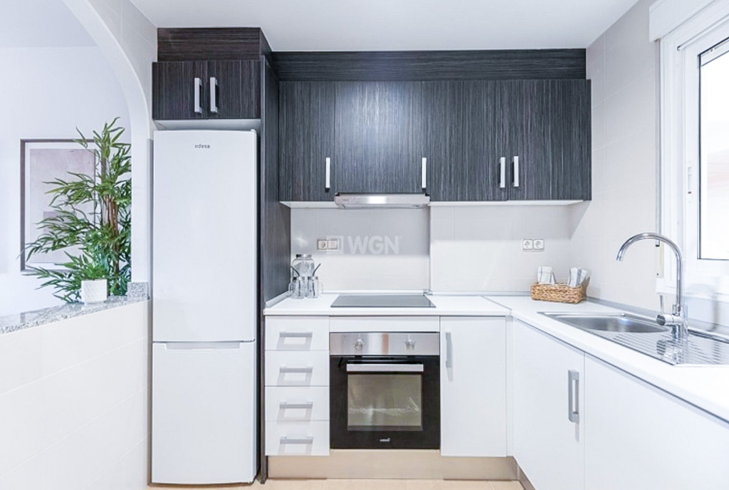 kuchnia w czerni i bieli w ekskluzywnym apartamencie na sprzedaż Hiszpania Orihuela Costa Cabo Roig