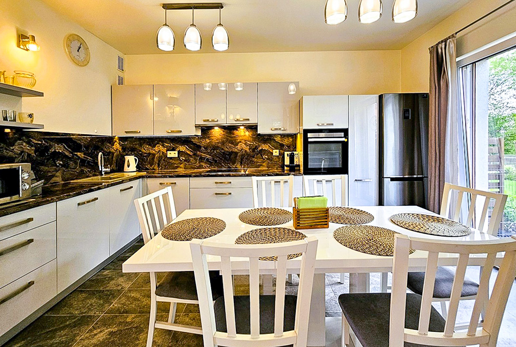 na pierwszym planie jadania, w oddali kuchnia w luksusowej willi na sprzedaż Wrocław okolice