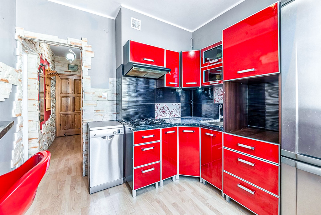 zaprojektowany w czerwieni aneks kuchenny w ekskluzywnym apartamencie na sprzedaż Gdynia okolice