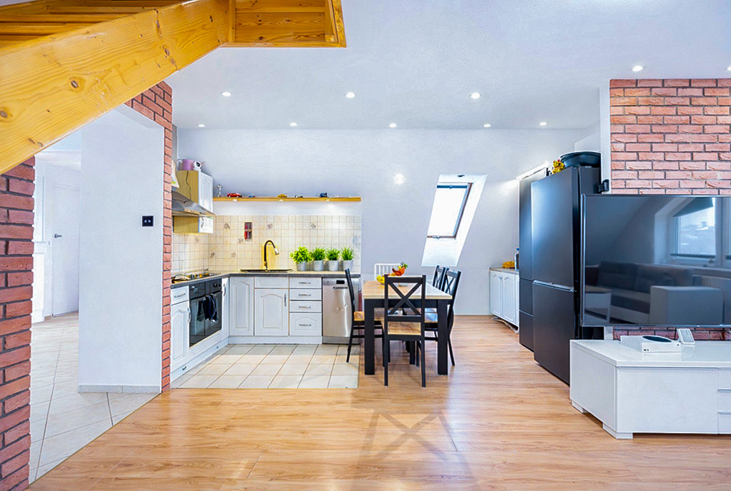 po lewej kuchnia, po prawej pokój gościnny w luksusowym apartamencie na sprzedaż Gdańsk