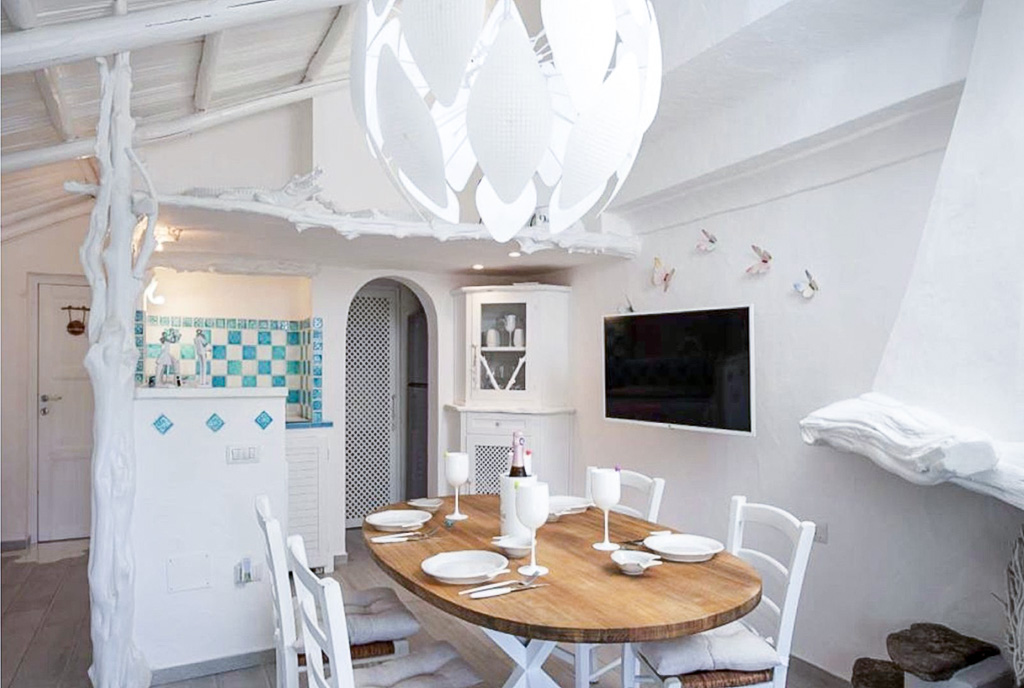 na pierwszym planie jadalnia, w oddali kuchnia w ekskluzywnym apartamencie na sprzedaż Włochy Porto Rotondo