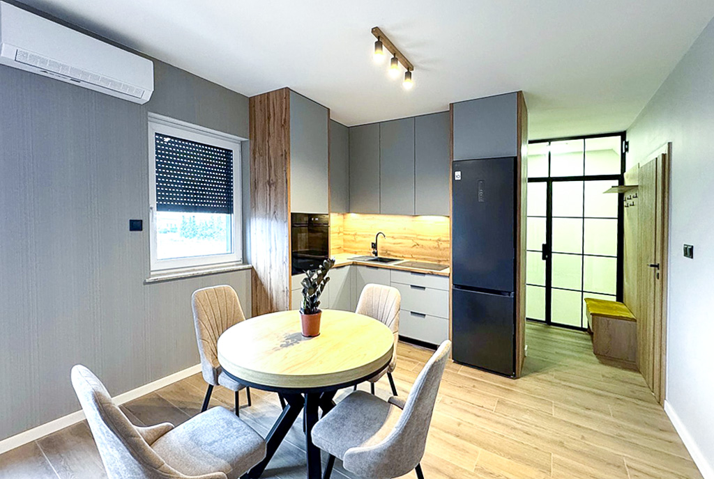 na pierwszym planie jadalnia, w oddali kuchnai w luksusowym apartamencie do wynajmu Ostrów Wielkopolski