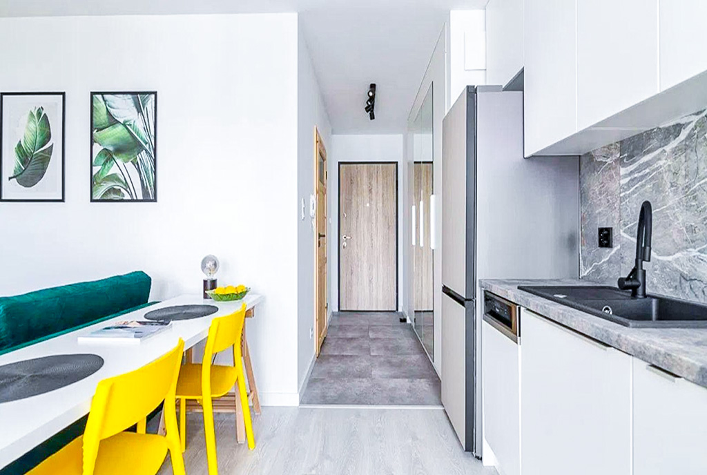 po lewej jadalnia, po prawej aneks kuchenny w luksusowym apartamencie na sprzedaż Gdańsk
