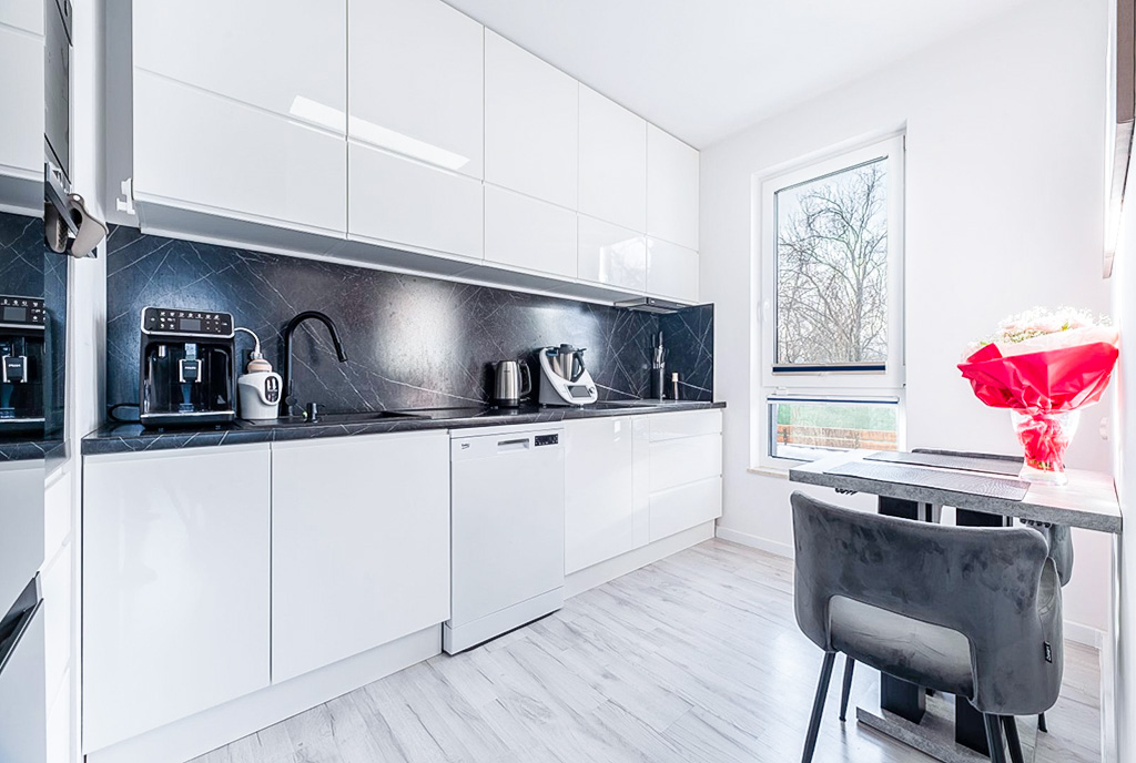 zaprojektowana w bieli kuchnia w ekskluzywnym apartamencie na wynajem Gdynia okolice