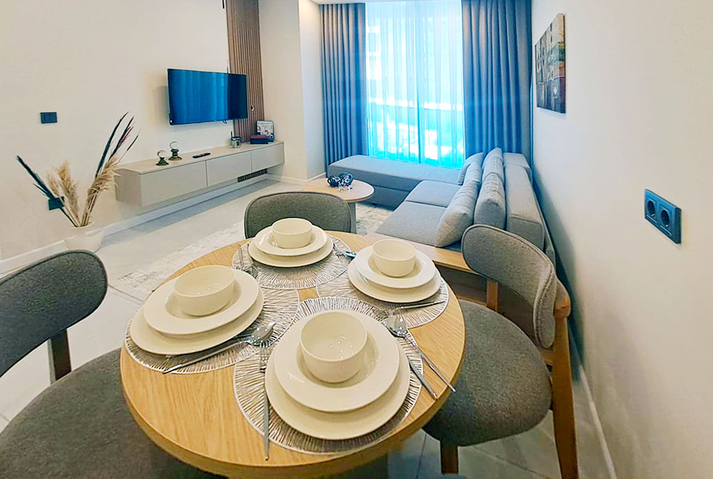 imponująca jadalnia na tle salonu w luksusowym apartamencie na sprzedaż Turcja Alanya