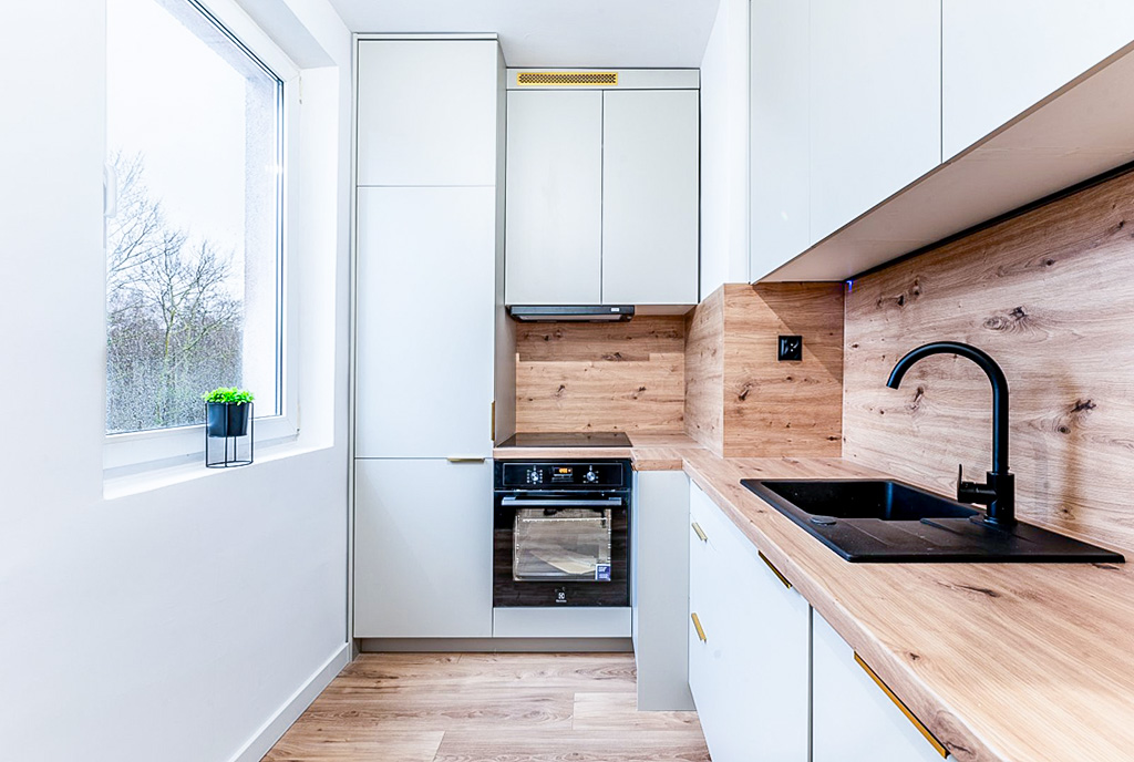 zaprojektowana w bieli kuchnia w luksusowym apartamencie na sprzedaż nad morzem
