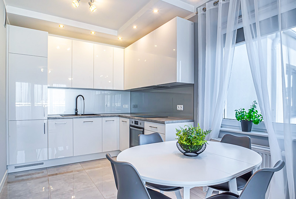 na pierwszym planie jadalnia, z nią kuchnia w luksusowym apartamencie do wynajmu Bolesławiec