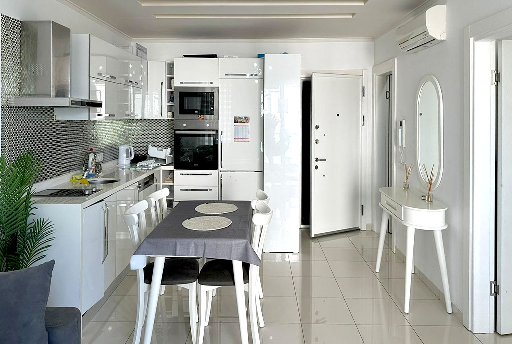na pierwszym planie jadalnia, w oddali kuchnia w luksusowym apartamencie na sprzedaż Turcja Alanya