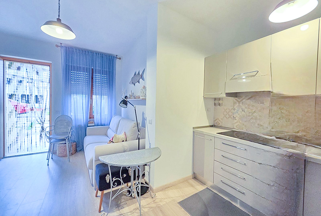 na zdjęciu aneks kuchenny i salon w luksusowym apartamencie na sprzedaż Włochy (Lu Bagnu)