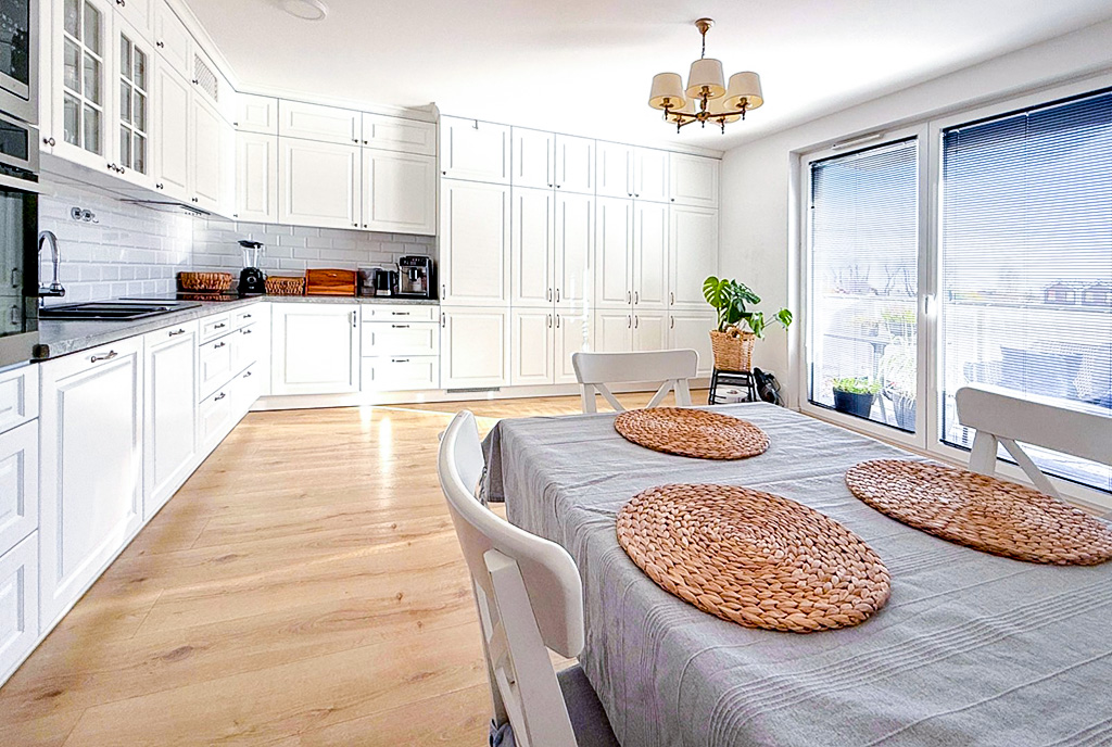 na pierwszym planie jadalnia, oddali kuchnia w ekskluzywnym apartamencie do sprzedaży Gdynia okolice